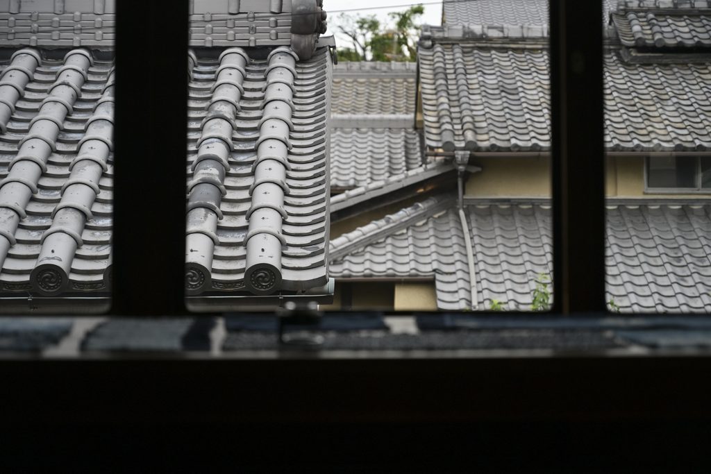 View of tiled rooftops from SASHIKO BORO ARCHIVE window