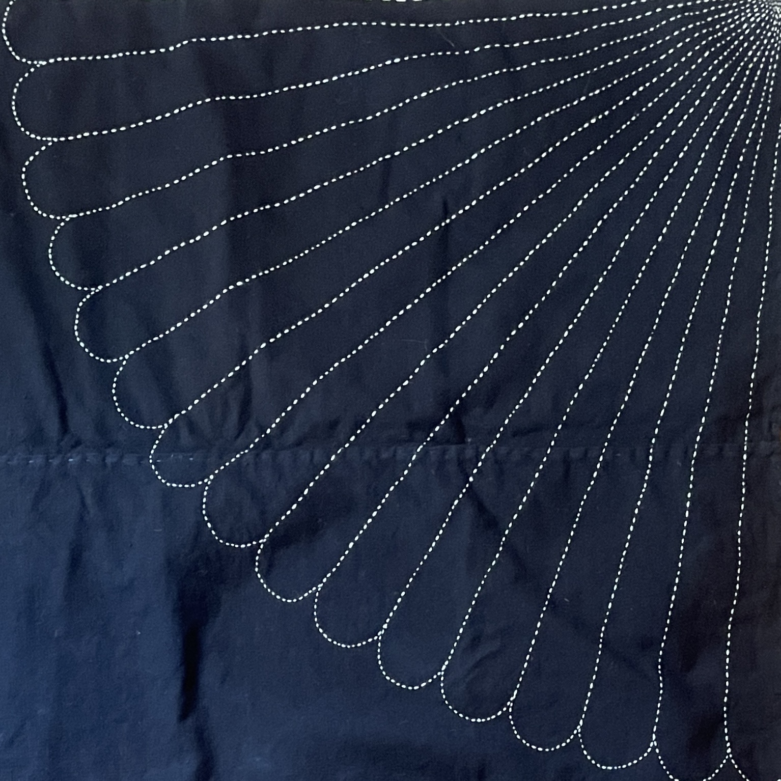 White sashiko stitching in a radiating Warikiku pattern on dark indigo cloth